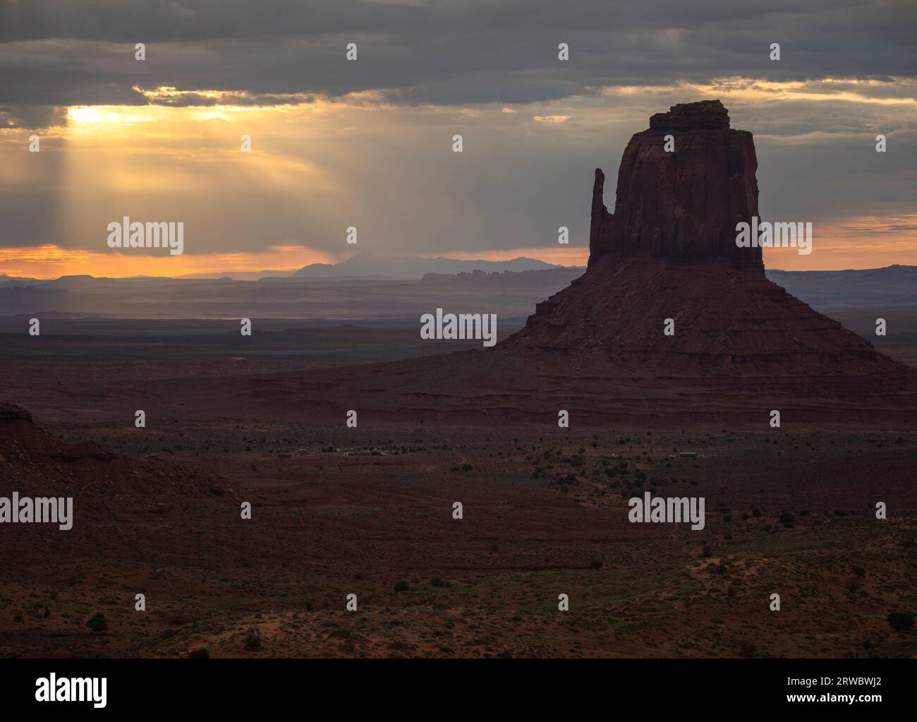 Formation rocheuse située sur un vaste terrain à Monument Valley sous le ciel du coucher du soleil plein de nuages en Amérique Banque D'Images