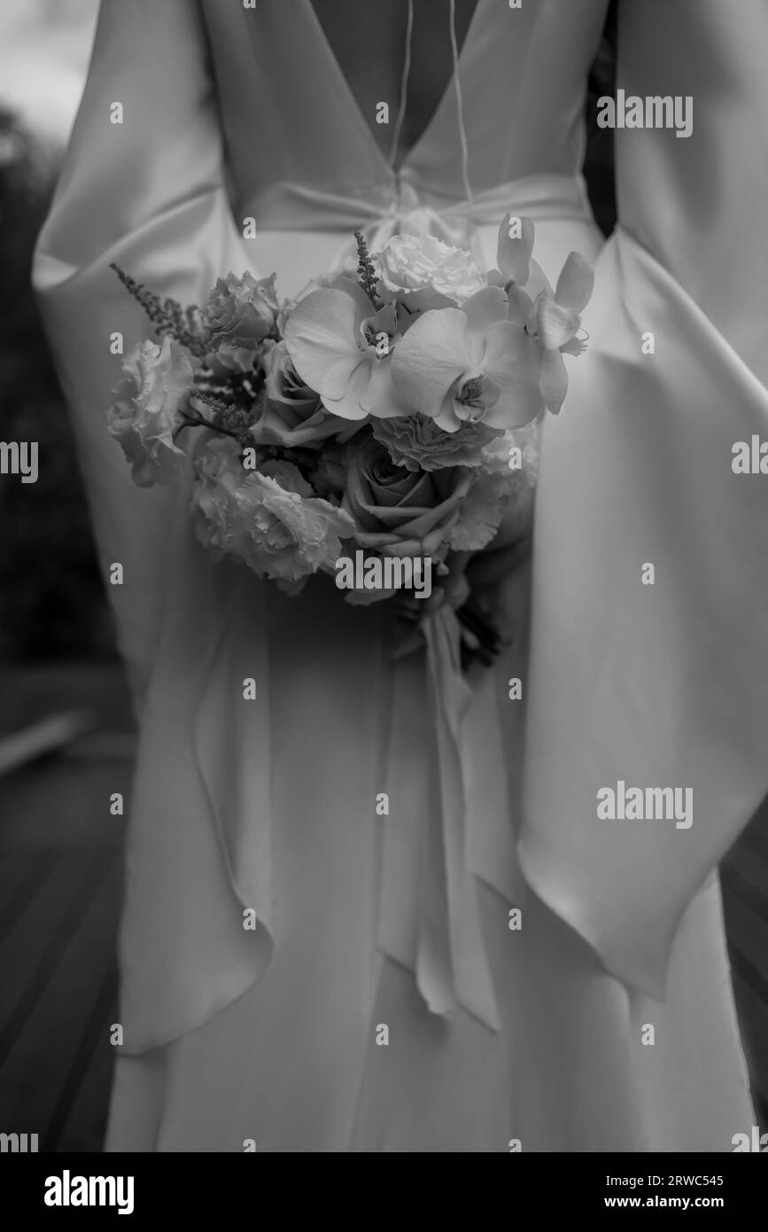 jeune fille dans une robe de mariée blanche tient dans ses mains un bouquet de fleurs. Photo de haute qualité Banque D'Images