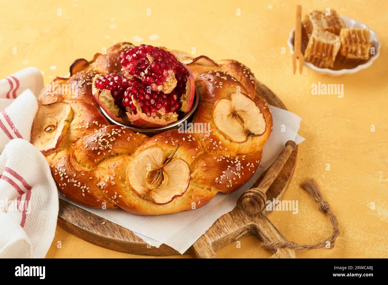 Fêtes juives - Rosh Hashana ou Rosh Hashana. Grenade, pommes, miel et challah rond sur fond de table jaune rustique. Célébration d'automne juif Banque D'Images