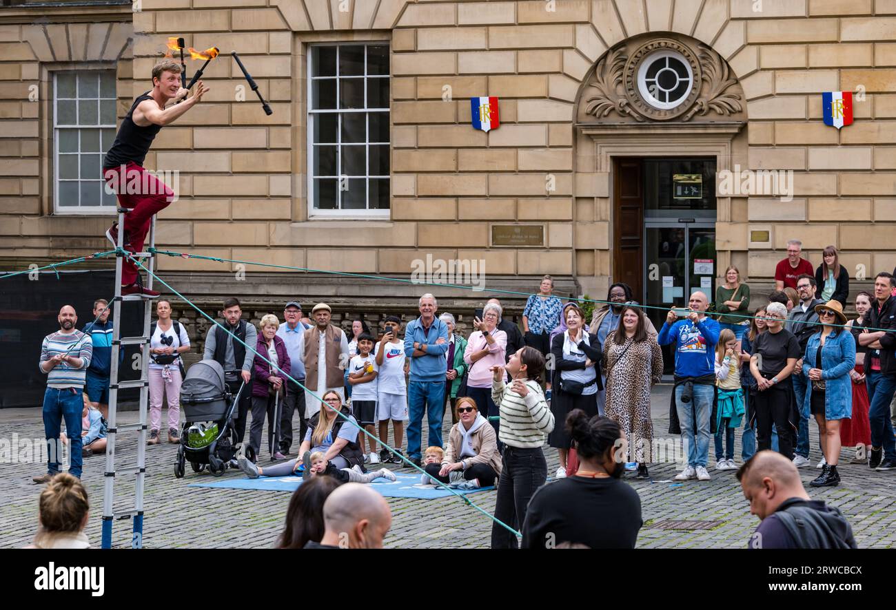 Artiste de rue jonglant avec des torches de feu debout sur une échelle, Edinburgh Festival Fringe, Parliament Square, Écosse, Royaume-Uni Banque D'Images