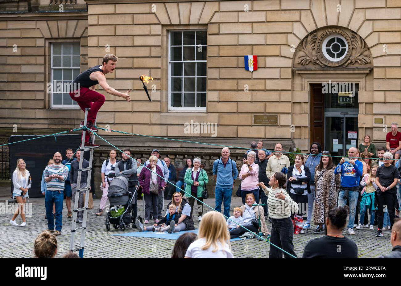 Artiste de rue jonglant avec des torches de feu debout sur une échelle, Edinburgh Festival Fringe, Parliament Square, Écosse, Royaume-Uni Banque D'Images