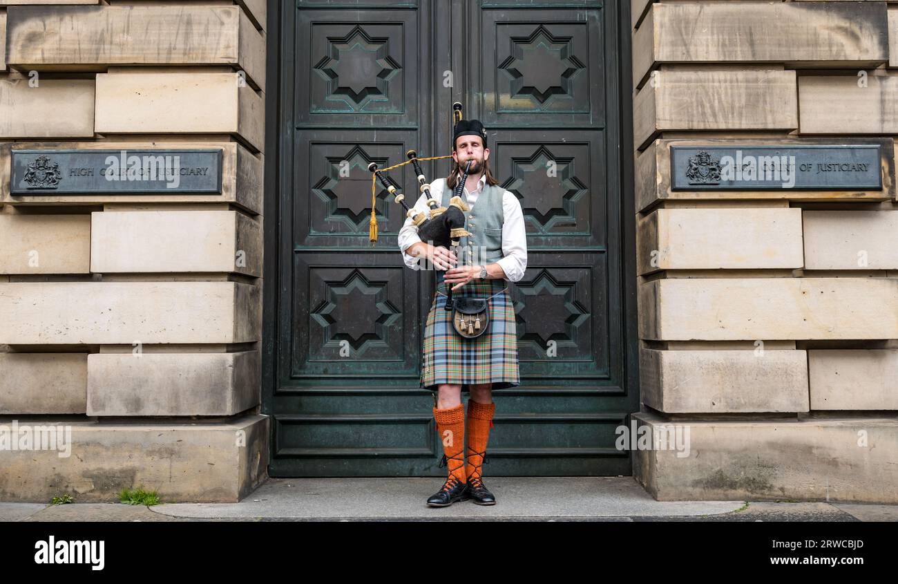 Cornemuse Playerwear kilt Busking devant la High court of Justiciary, Royal Mile, Édimbourg, Écosse, Royaume-Uni Banque D'Images