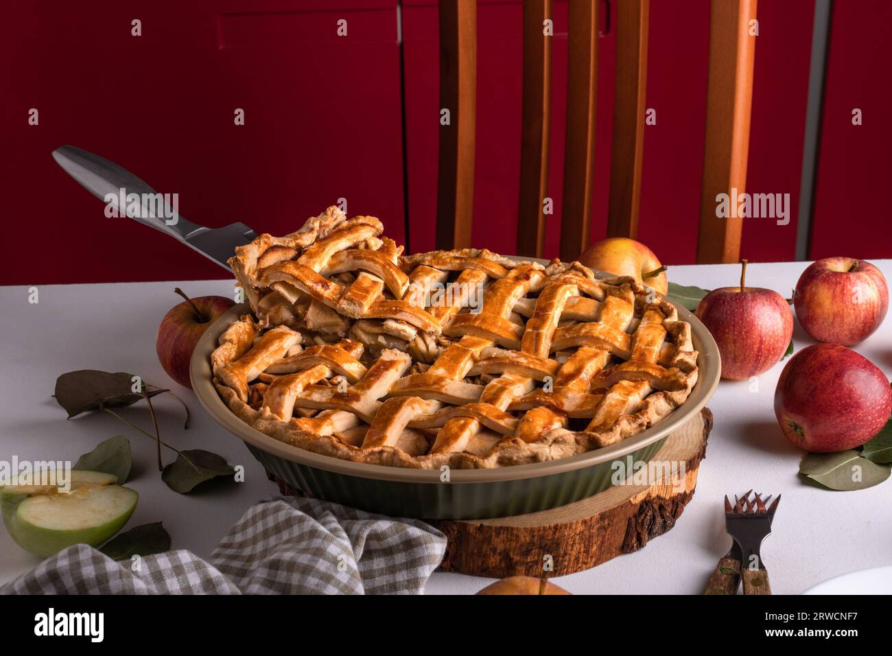 Tarte aux pommes maison avec des pommes fraîches fermer avec une tranche savoureuse sur le couteau, mode de vie gourmand. Dessert traditionnel de Thanksgiving, préparation à la tarte de Thanksgiving Banque D'Images