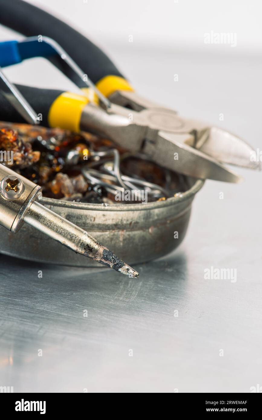 Fer à souder avec étain, colophane et pinces sur la table d'atelier Banque D'Images