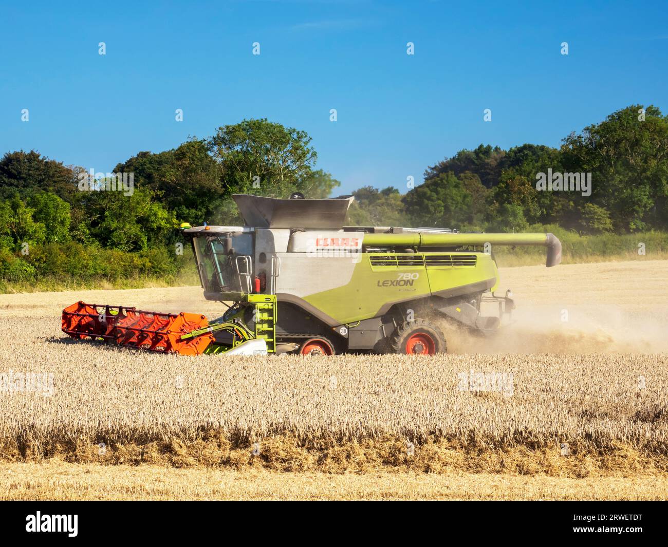 Un agriculteur récoltant un champ de blé à Cley Next the Sea, Norfolk, Royaume-Uni. Banque D'Images