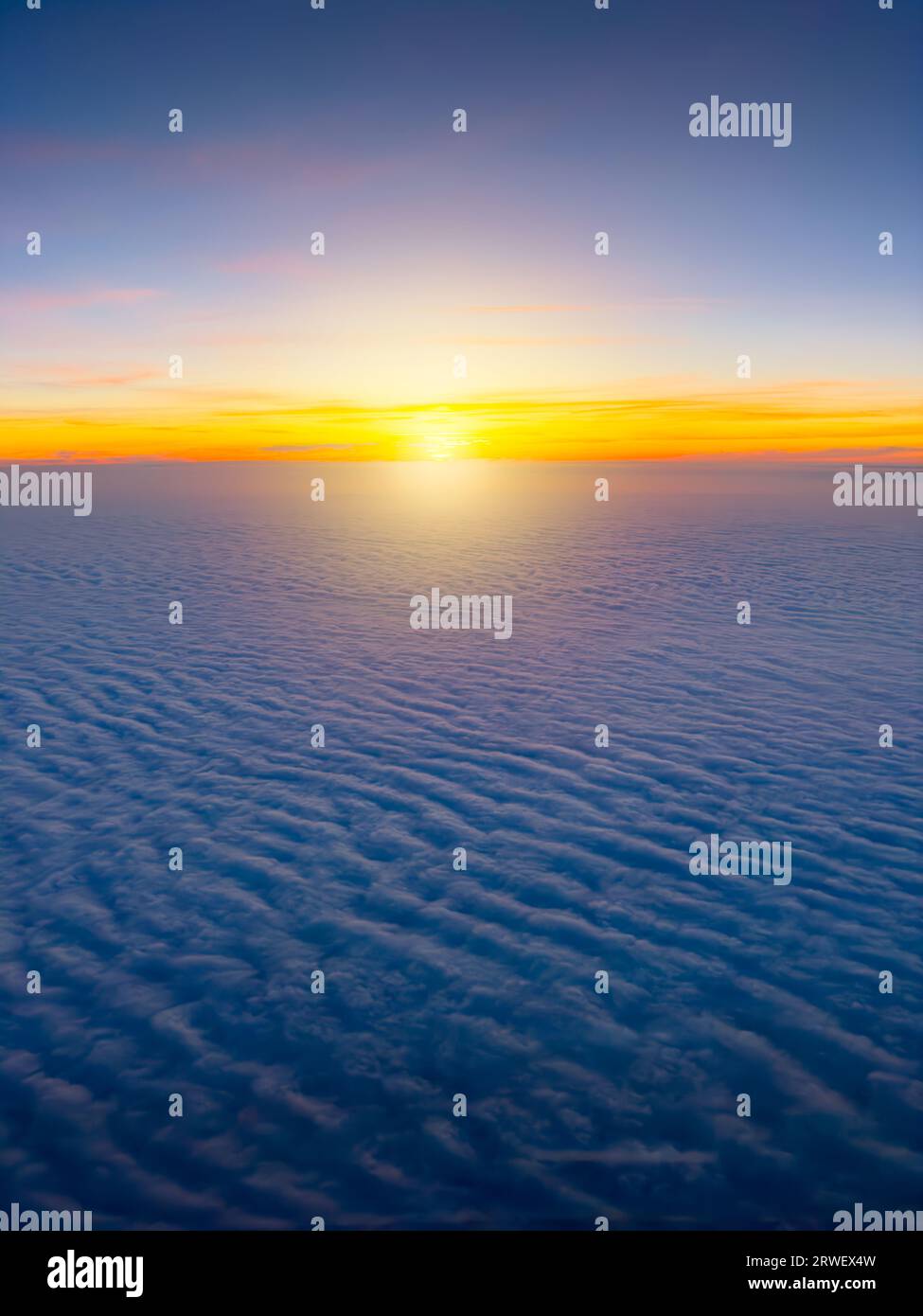 Lever de soleil vu d'un avion volant au-dessus des nuages Banque D'Images