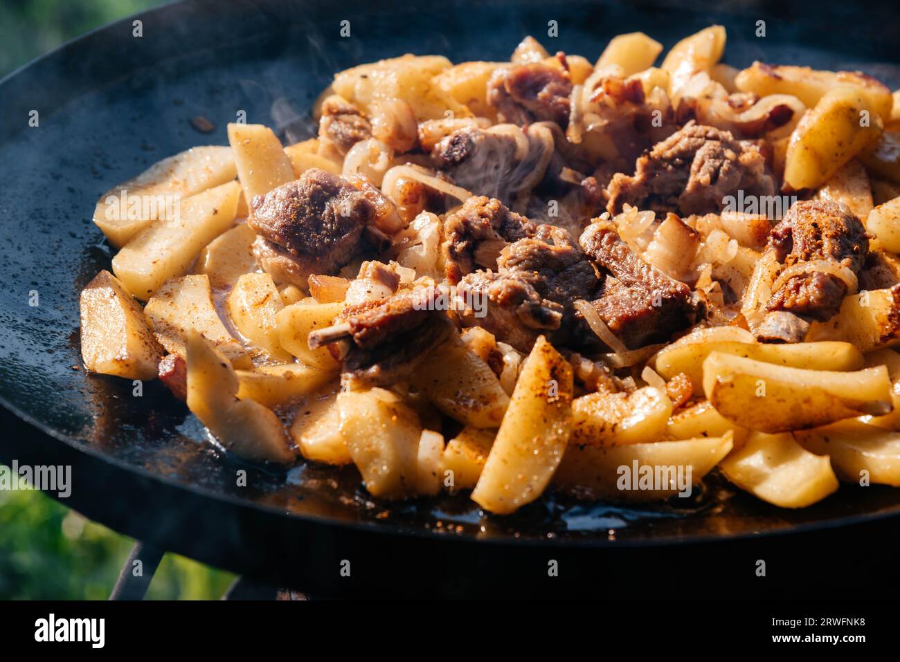 Viande frite et pommes de terre sur un pique-nique. Cuisiner à l'extérieur. Banque D'Images