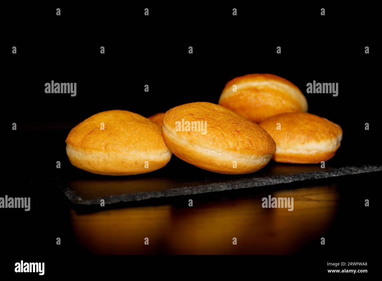 Krapfen traditionnel sans glaçure sur fond noir. Dessert d'Allemagne Banque D'Images