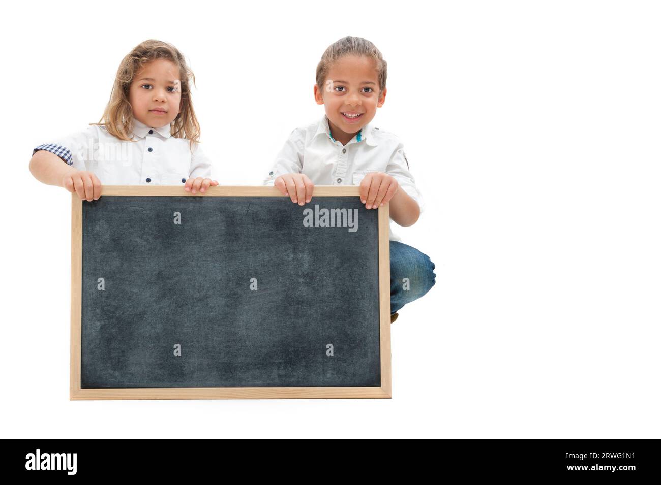 Inglese : deux enfants multiethniques aux cheveux longs tiennent un tableau blanc dans leurs mains, sur fond blanc Banque D'Images