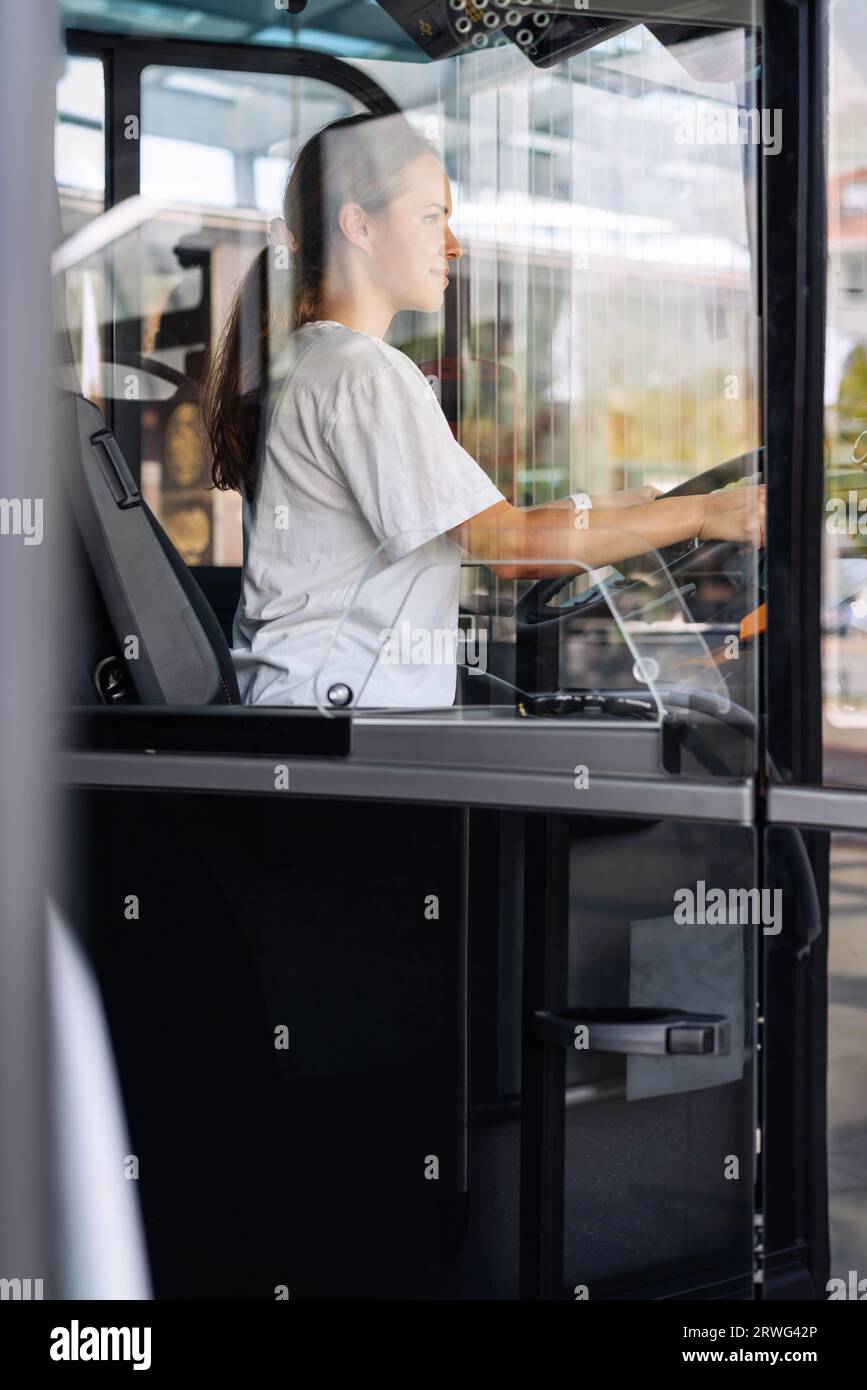 Jeune femme adulte chauffeur de bus de ville, profession féminine. Banque D'Images