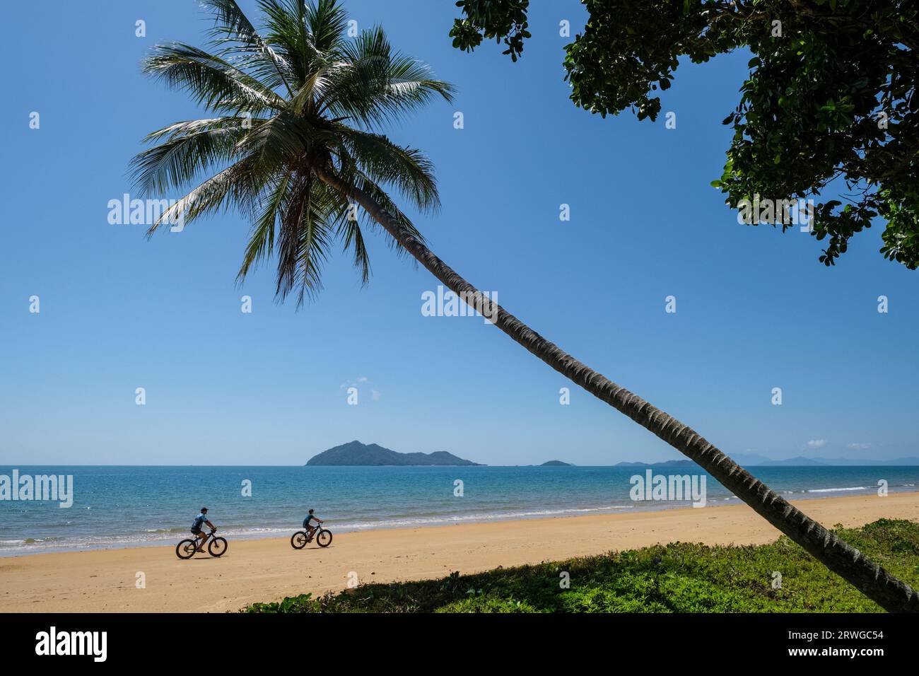 Cyclistes sur la plage de Wongaling avec une vue vers Dunk Island, Mission Beach, Queensland, Australie Banque D'Images