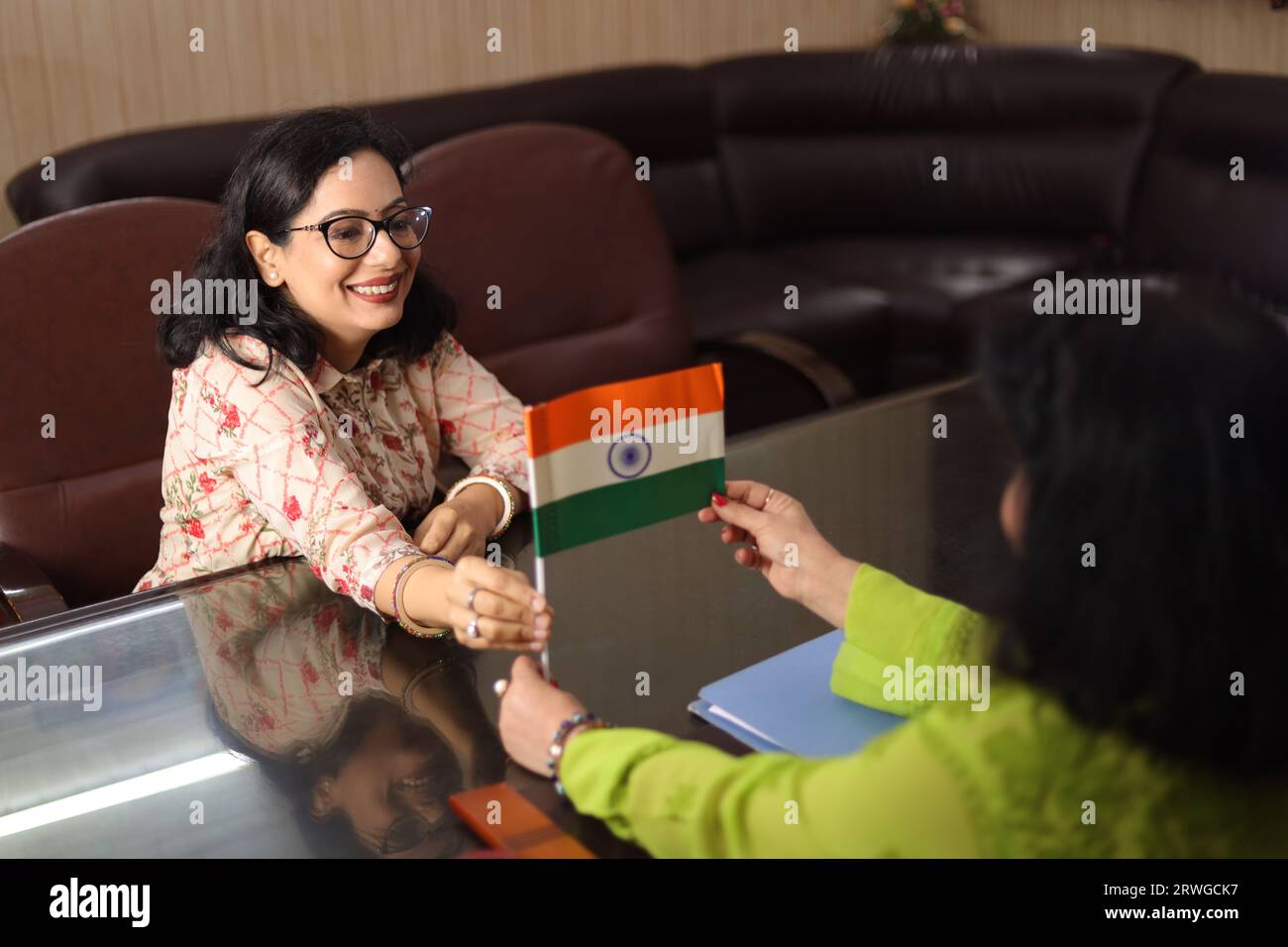 Principale Ma'am donnant un drapeau indien à un enseignant en cadeau, réunion de parents enseignants, PTM, femmes, bureau principal, courtoisie, professionnalisme, récompense. Banque D'Images