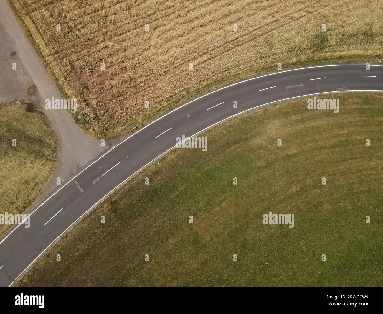 Vue aérienne d'une route entre les champs de culture et d'herbe dans le paysage Banque D'Images