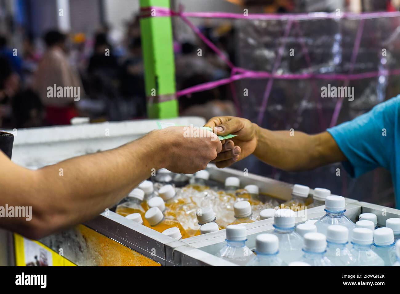 Touriste donnant de l'argent de ringgit malaisien à un vendeur malaisien pour acheter du jus frais dans la nourriture de rue Jalan Alor Banque D'Images