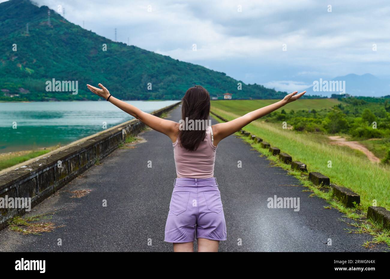 Jeune femme russe voyageur avec les bras ouverts près du lac et des montagnes dans la province de Khanh Hoa, Vietnam Banque D'Images