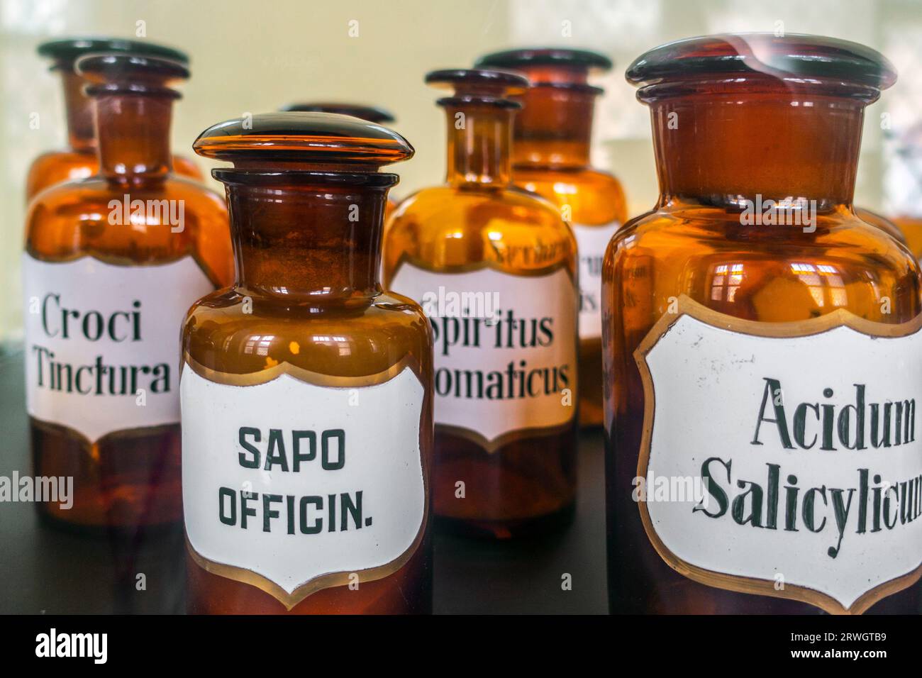 Bocaux / bouteilles en verre ambré apothicaire antique avec spiritus aromaticus, acidum salicylicum, Saponaria officinalis, Croci tinctura en pharmacie vintage Banque D'Images