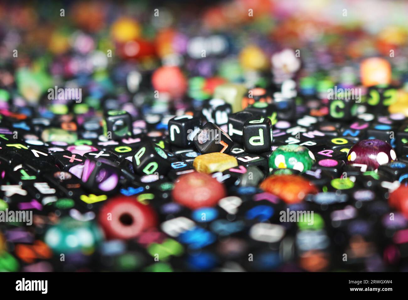 image abstraite de dés/cubes en plastique de couleur noire sur des lettres de l'alphabet Banque D'Images