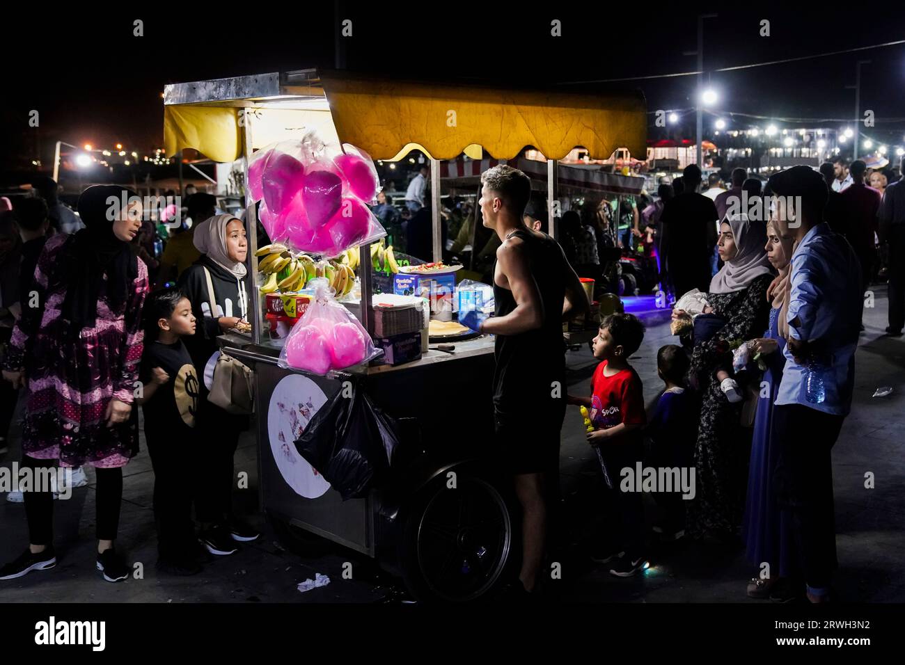 Les gens à un stand de nourriture. Pour le festival de briser le jeûne (Eid Mubarak) à la fin du Ramadan, les gens célèbrent sur la promenade de la plage de la Corniche. Tripoli, Liban. Banque D'Images