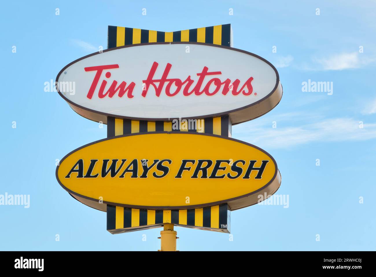 Tim Hortons signe photographié contre une mouche bleue. Banque D'Images