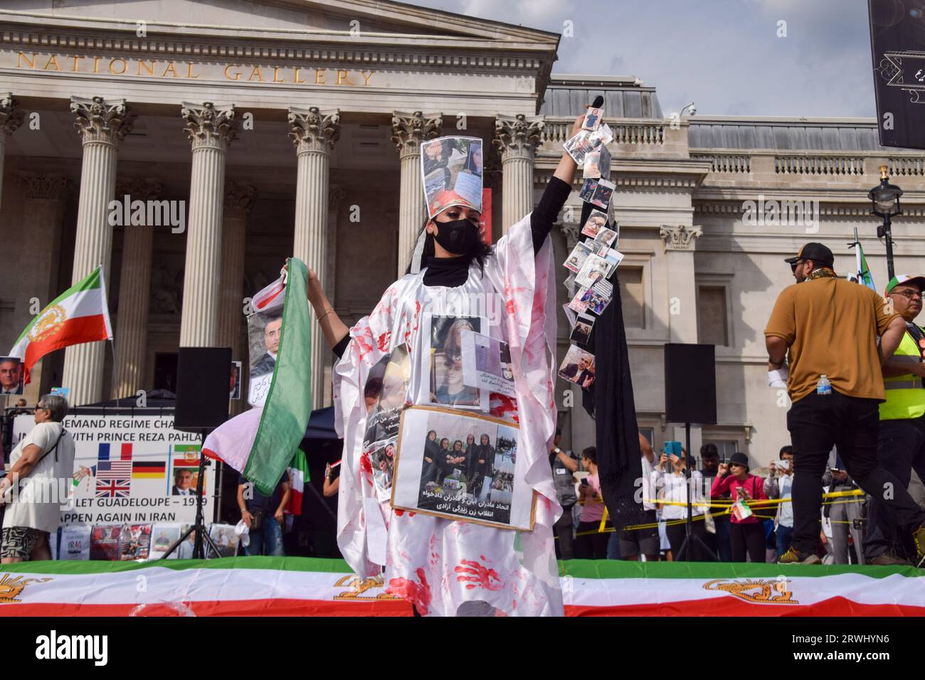 Londres, Royaume-Uni. 16 septembre 2023. Un manifestant est couvert de faux sang et de photos des victimes du régime iranien pendant le rassemblement à Trafalgar Square. Les Iraniens britanniques ont organisé plusieurs manifestations autour de Londres contre le régime iranien pour marquer l'anniversaire de la mort de Mahsa Amini, ainsi que les manifestations et la répression gouvernementale qui ont suivi en Iran. (Image de crédit : © Vuk Valcic/SOPA Images via ZUMA Press Wire) USAGE ÉDITORIAL SEULEMENT! Non destiné à UN USAGE commercial ! Banque D'Images