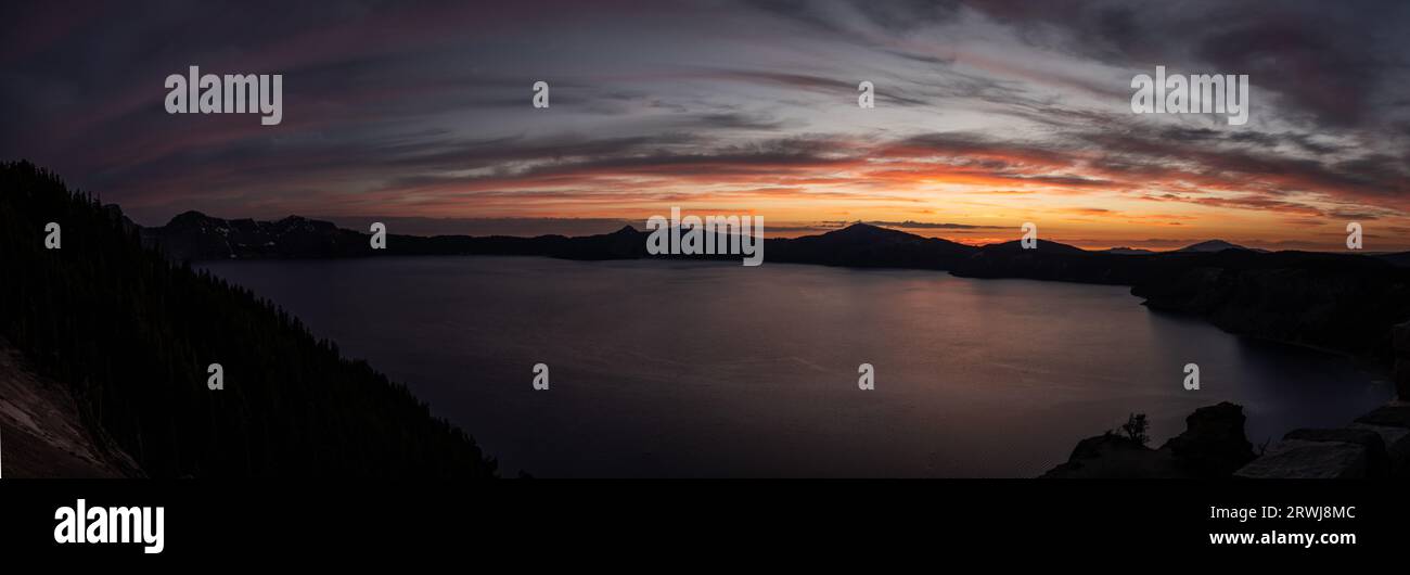 Vue large du lac Crater et des silhouettes de falaise alors que la lumière s'estompe au crépuscule Banque D'Images