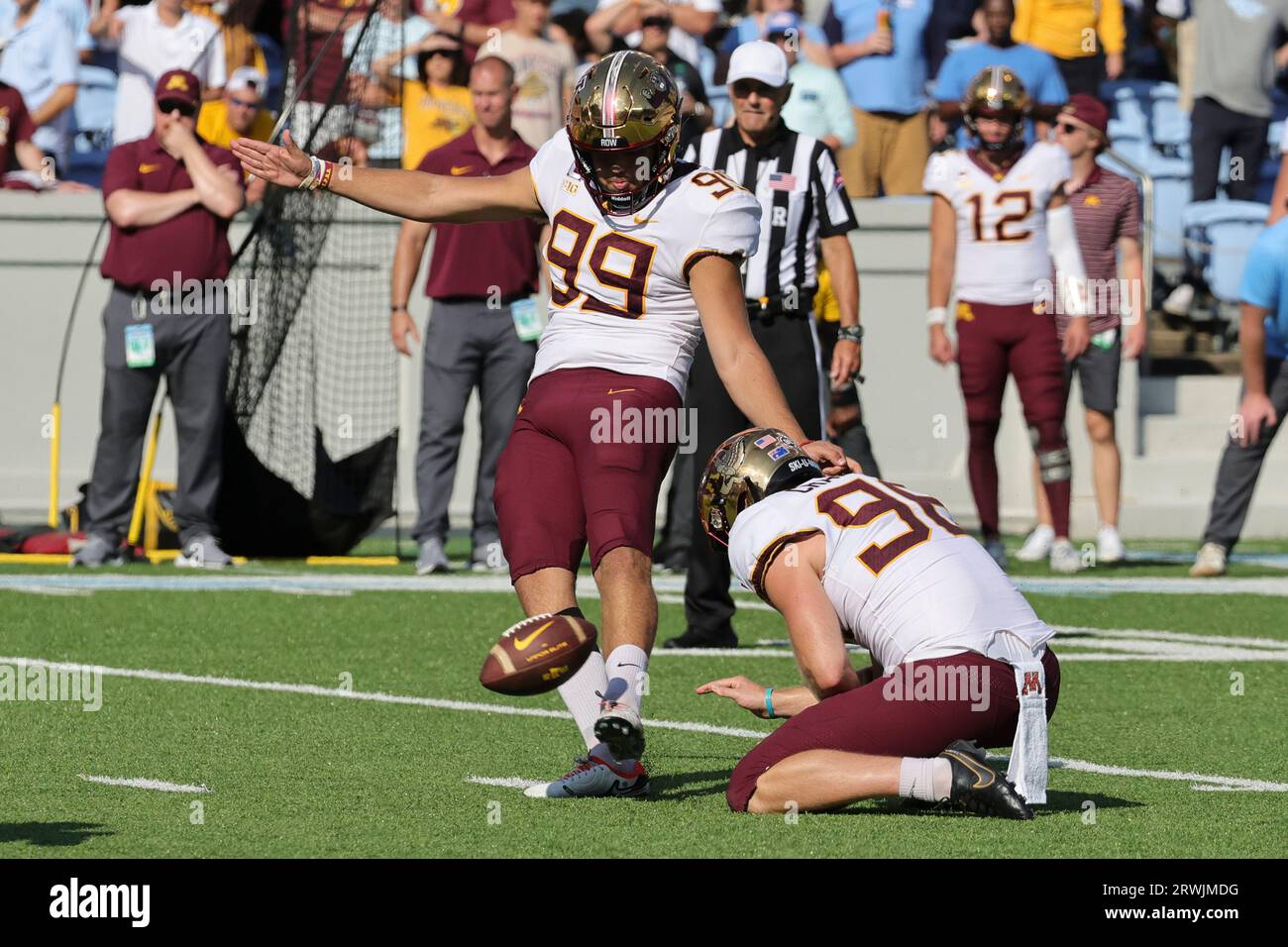 Minnesota place kicker Dragan Kesich (99) kicks a field goal from the hold of Minnesota place kicker David Kemp (98) during the second quarter of an NCAA college football game against North Carolina, Saturday, Sept. 16, 2023, in Chapel Hill, N.C. (AP Photo/Reinhold Matay) Banque D'Images