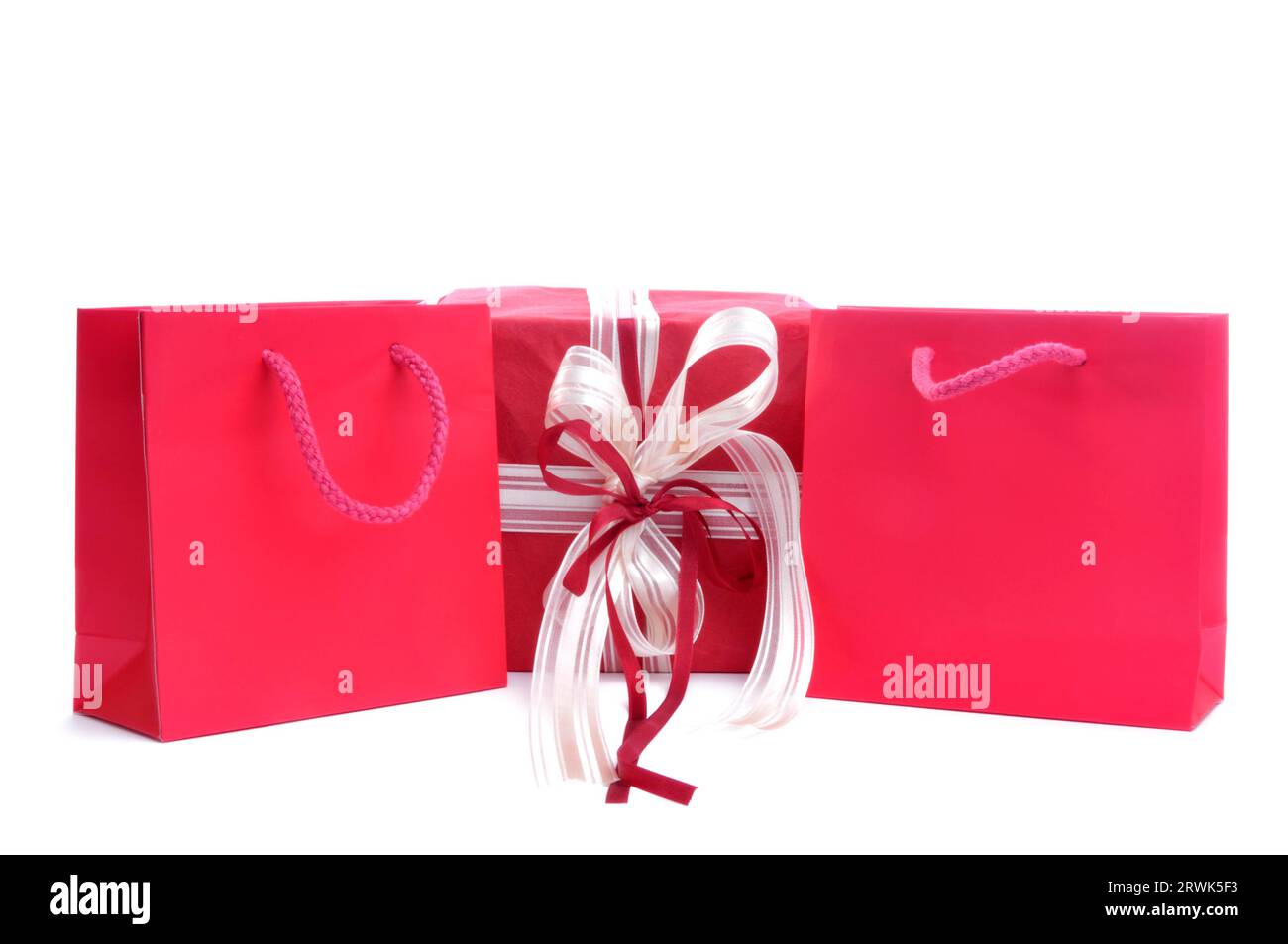 2 sacs à provisions rouges et un cadeau. Cadeaux symboliques de Noël Banque D'Images