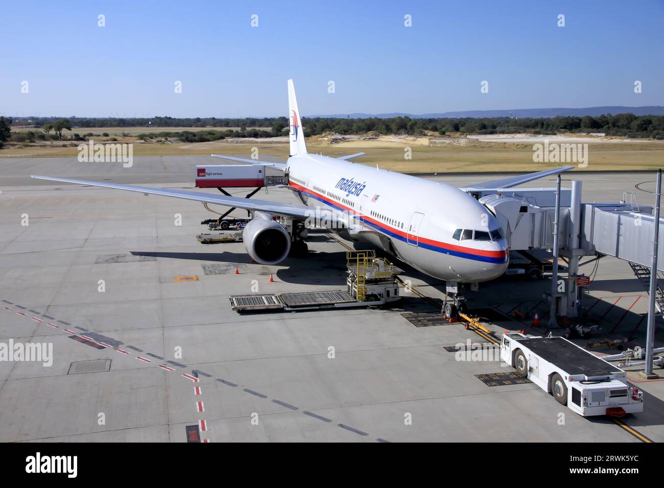 Malaysian Airlines avion préparant les passagers à embarquer et l'équipage au sol chargeant les bagages Banque D'Images