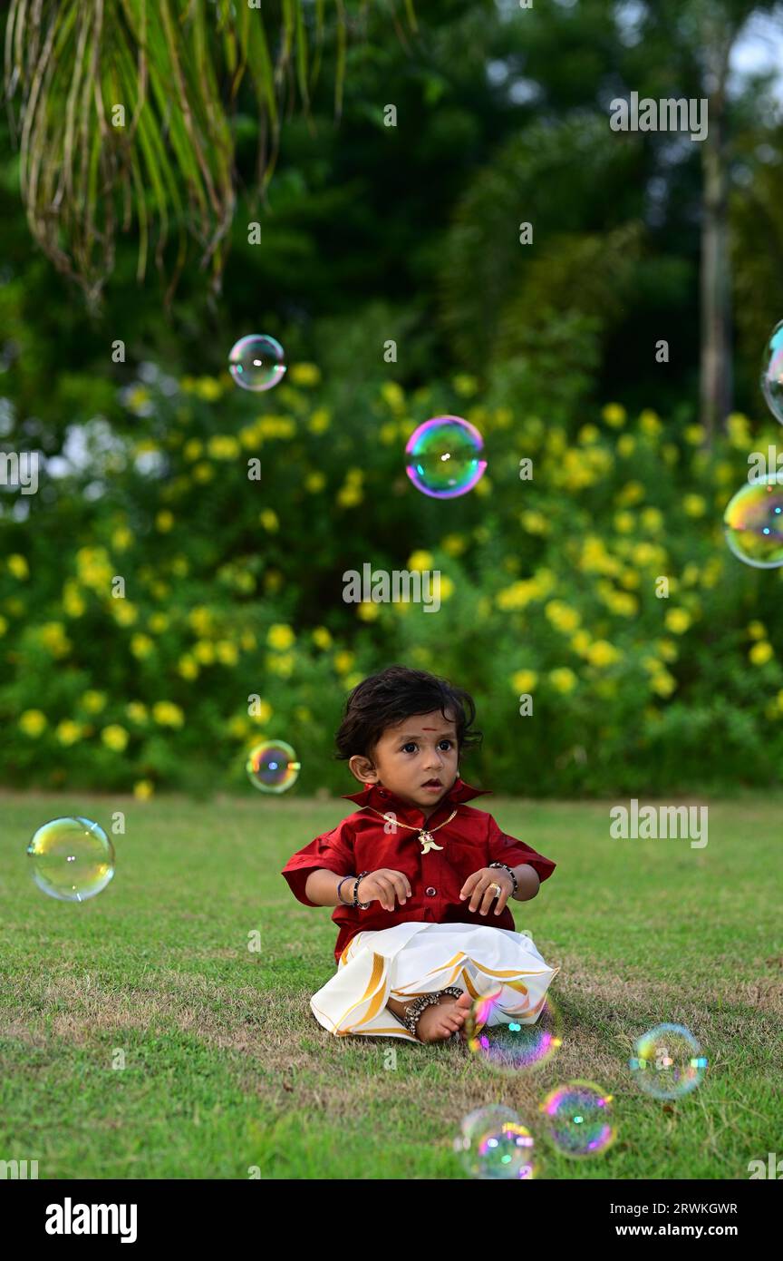 Indien traditionnel - style indien Dhoti et chemise - 1 ans garçon bébé - Garden sitting Baby - Bubbles - blanc Dhoti et chemise rouge Banque D'Images