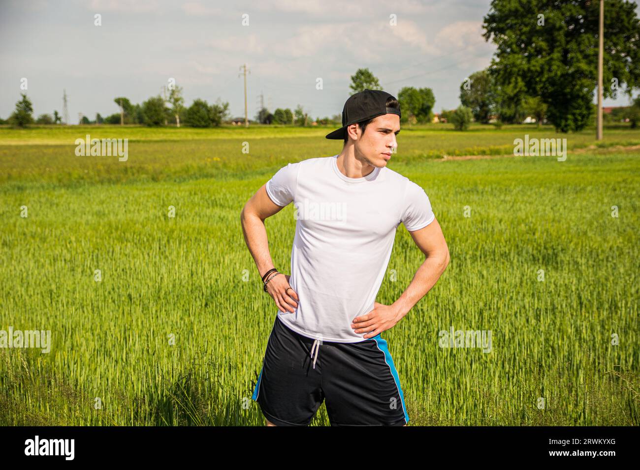 Un homme debout dans un champ avec ses mains sur ses hanches. Photo d'un jeune athlète debout avec confiance dans un terrain avec ses mains sur ses hanches Banque D'Images