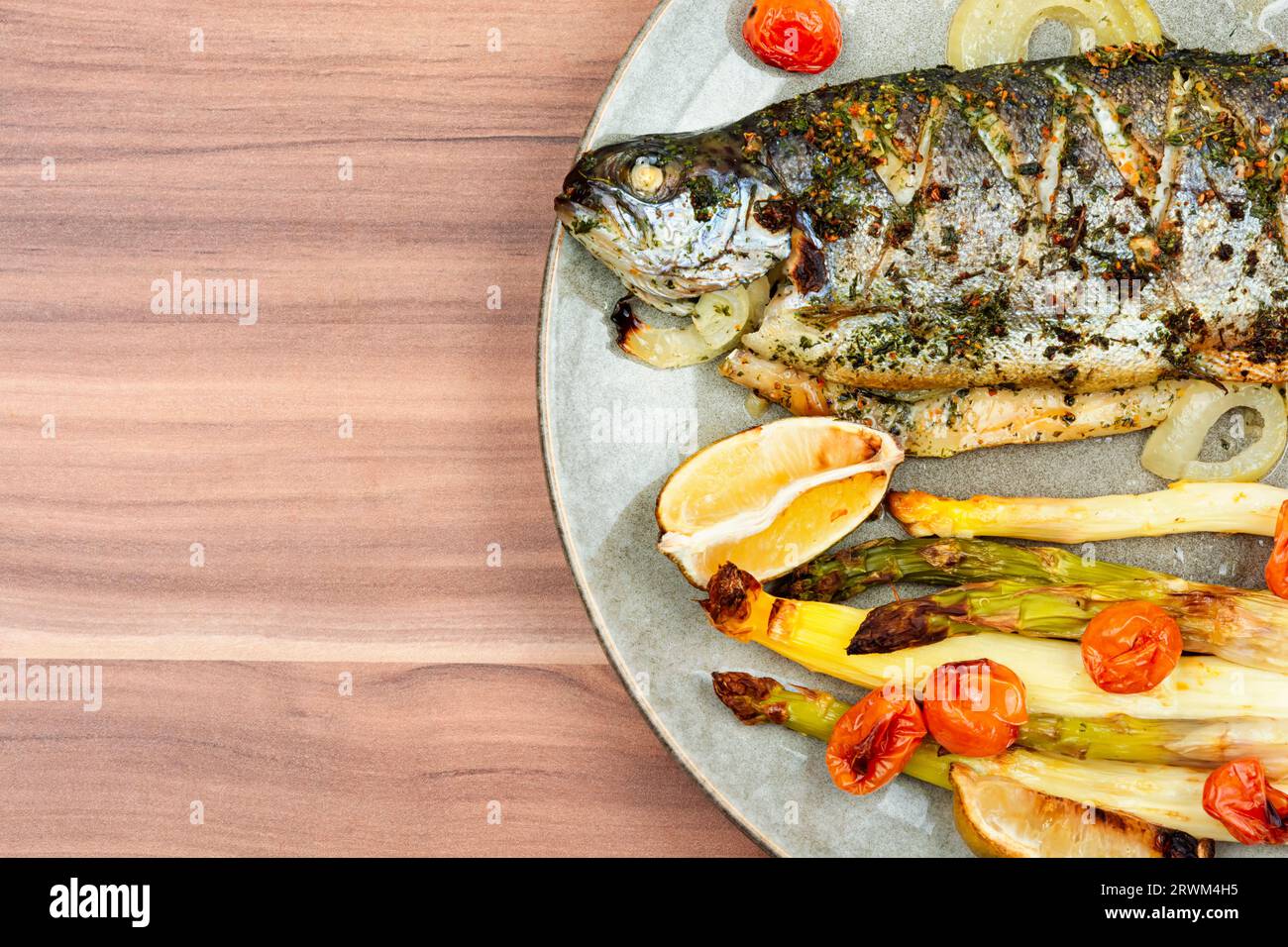 Truite grillée aux asperges. Poisson saumon cuit au four sur la table en bois. Espace de copie. Banque D'Images