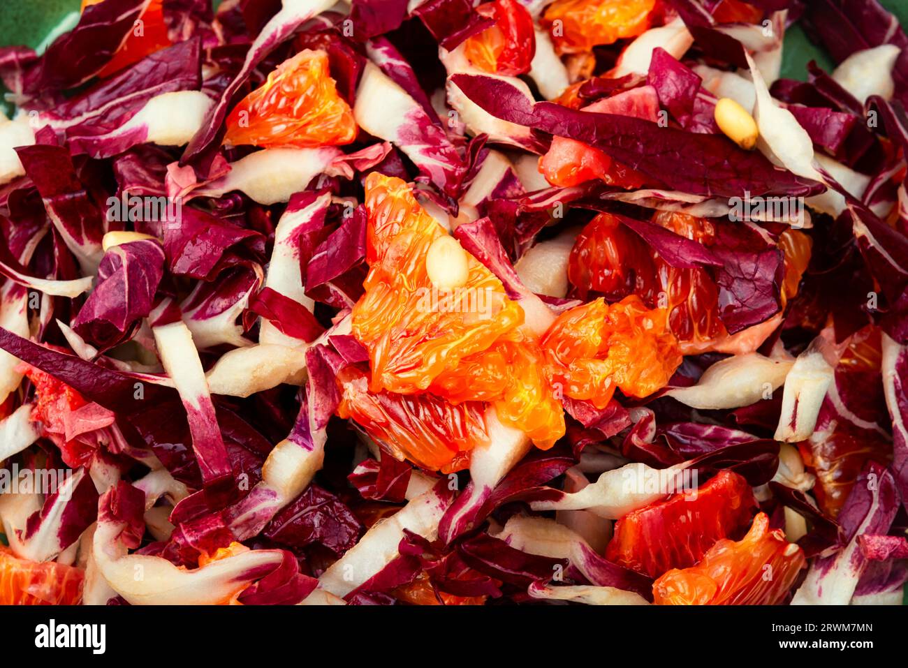 Salade savoureuse avec chicorée rouge, pamplemousse et pignons de pin sur la table. Gros plan Banque D'Images