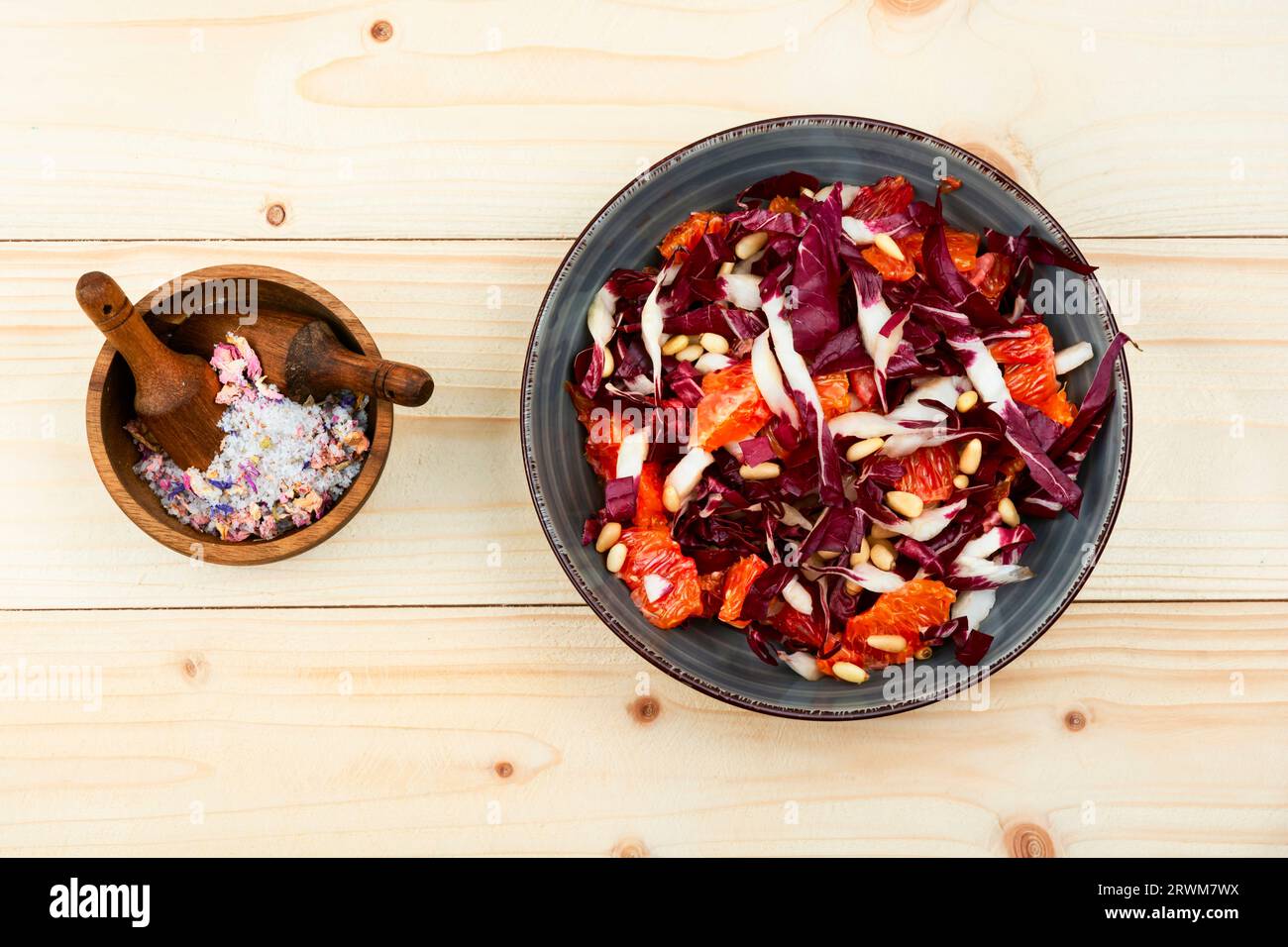 Salade avec chicorée, pamplemousse et pignons de pin sur table en bois. Salade de radicchio Banque D'Images