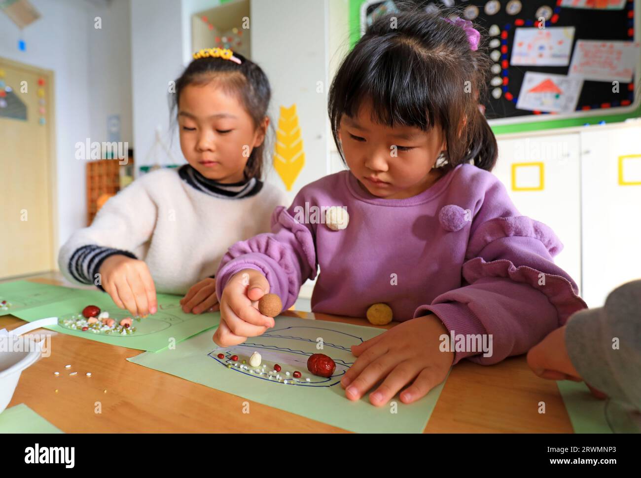 COMTÉ de LUANNAN, Chine - 7 janvier 2022 : les enfants de maternelle font des devoirs manuels au Festival Laba, Chine du Nord Banque D'Images