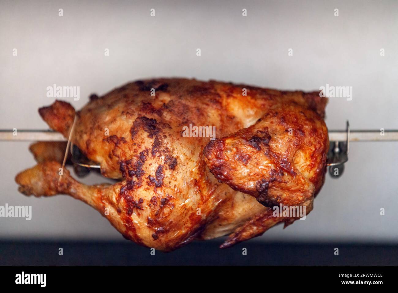 Un poulet rôti est un plat de poulet qui est cuit sur une rôtisserie en utilisant la chaleur directe dans laquelle le poulet est placé à côté de la source de chaleur. Banque D'Images