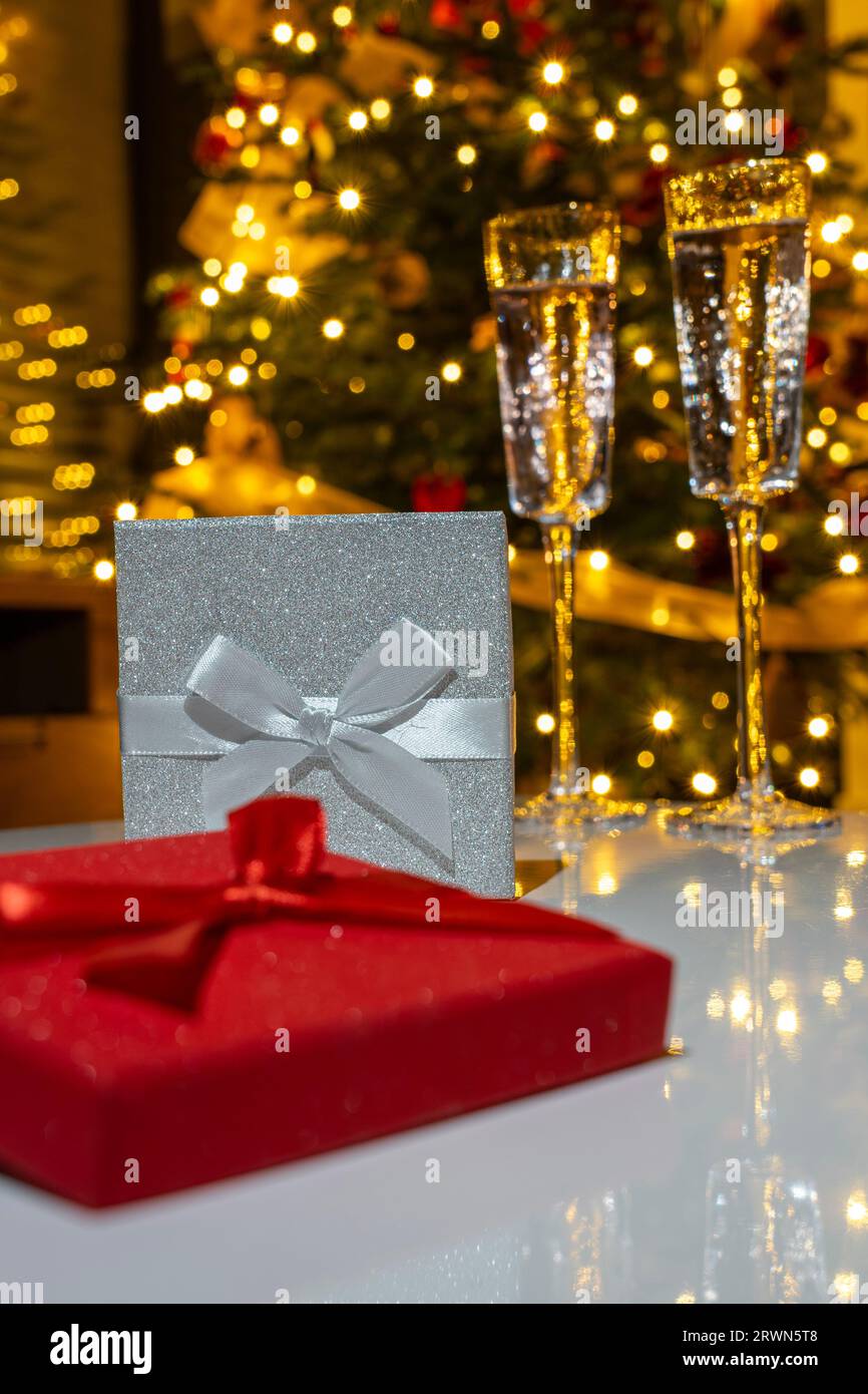 veille de noël romantique avec des verres à champagne cadeau et lumières de noël sur l'arbre. Banque D'Images