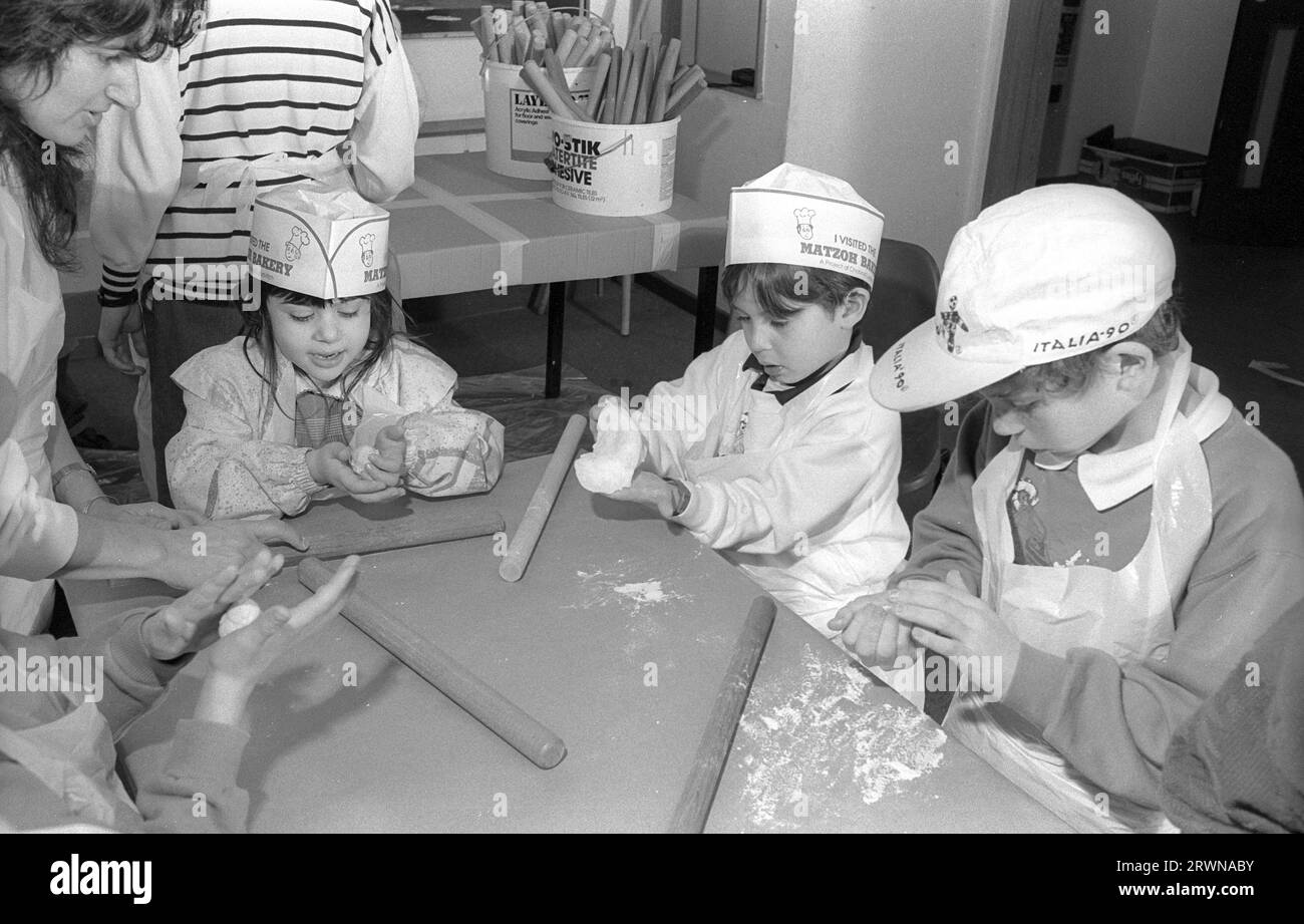 Des enfants juifs des Congrégations hébraïques de Birmingham et Solihull ont participé à une boulangerie matzo pré-PÂQUE en mars 1991 au Centre Lubavitch à Willows Road Birmingham. Enseignant aux enfants les règles de cuisson du pain sans levain sont Rabbi Herchel Rader, ministre de la synagogue de Solihull et le professeur Sam Aburdaram, directeur de l'école de cheder de Solihull Banque D'Images