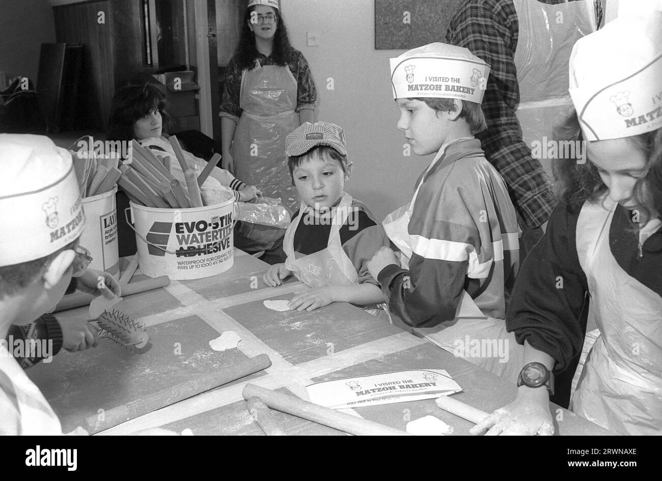 Des enfants juifs des Congrégations hébraïques de Birmingham et Solihull ont participé à une boulangerie matzo pré-PÂQUE en mars 1991 au Centre Lubavitch à Willows Road Birmingham. Enseignant aux enfants les règles de cuisson du pain sans levain sont Rabbi Herchel Rader, ministre de la synagogue de Solihull et le professeur Sam Aburdaram, directeur de l'école de cheder de Solihull Banque D'Images