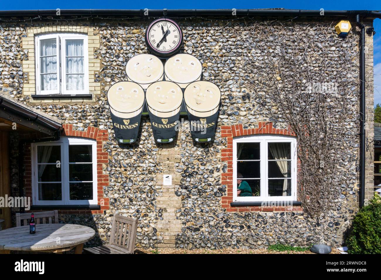 L'horloge Guinness sur le mur de la maison publique Elveden Inn à Elveden sur le bord de la forêt de Thetford. Banque D'Images