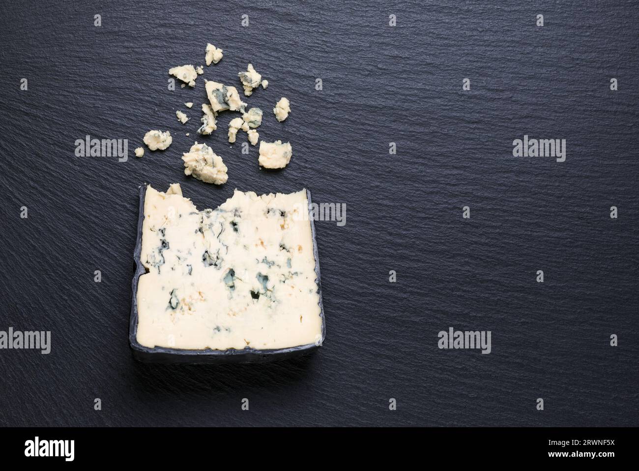 vue de dessus de morceaux savoureux fromage avec moule bleu sur fond d'ardoise noire. Banque D'Images