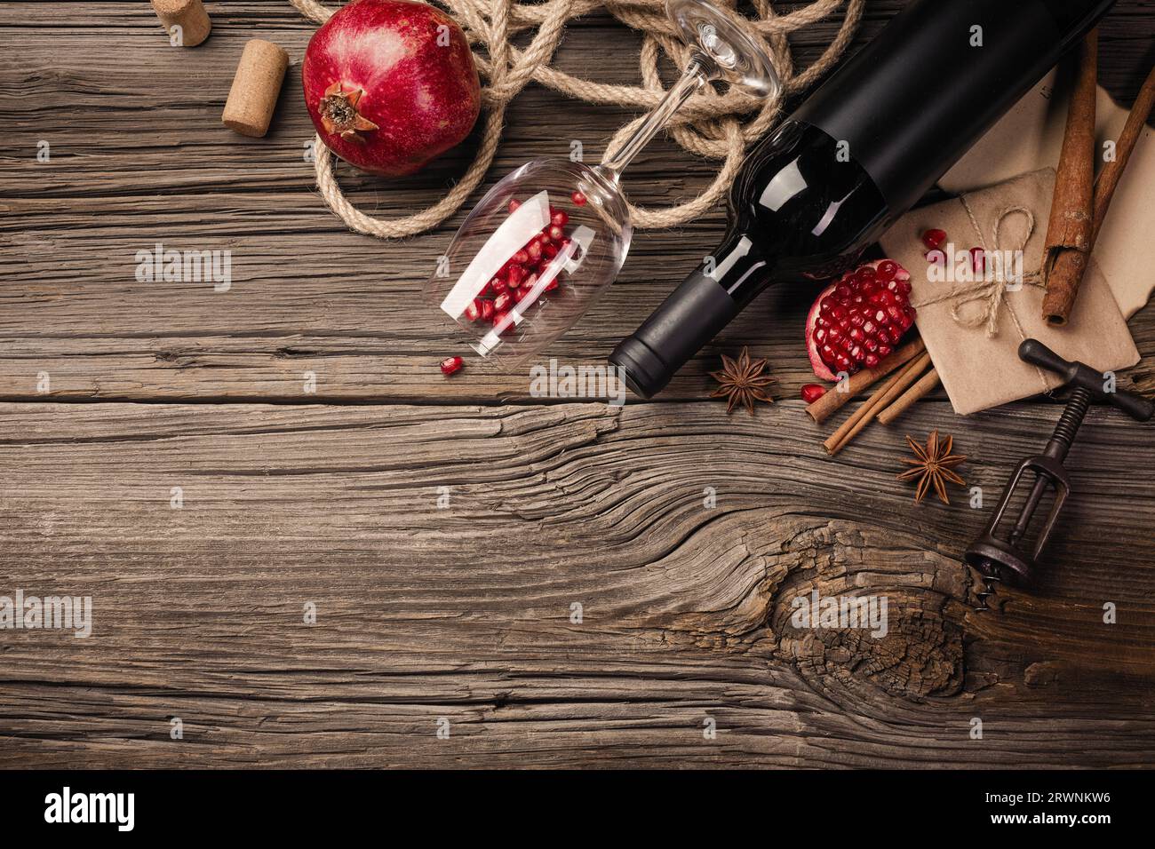 Fruit mûr de grenade avec un verre de vin, une bouteille sur un fond en bois. Vue de dessus avec espace de copie. Banque D'Images