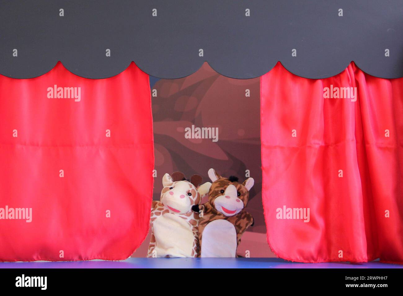 Théâtre Guignol activité culturelle et éducative pour enfants raconte une histoire dans une petite réplique d'un théâtre avec des marionnettes ou des poupées à gants en mouvement Banque D'Images