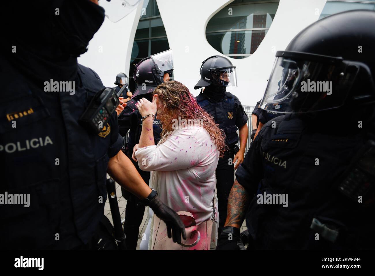 Un congressiste rempli de peinture en poudre rose est escorté par la police pendant le rassemblement. Manifestation contre le congrès du District de Barcelone où se sont rencontrés les principaux investisseurs des États réels à Barcelone. Les activistes bloquent l'entrée et jettent de la peinture en poudre sur les congresistes. Crédit : SOPA Images Limited/Alamy Live News Banque D'Images