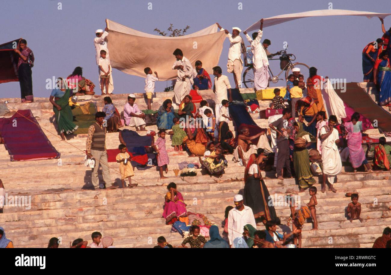 Inde : les pèlerins se baignent dans le réservoir sacré Jogula Bhavi, Saundatti, Karnataka, pendant la foire Shri Yellamma Devi (1994). Chaque année dans le mois hindou de Magh (janvier - février) plus d'un demi-million de personnes se rassemblent autour du minuscule temple de la déesse Yellamma à Saundatti. Yellamma est la patronne des devadasi ou des femmes dédiées au service d'une divinité ou d'un temple. Banque D'Images