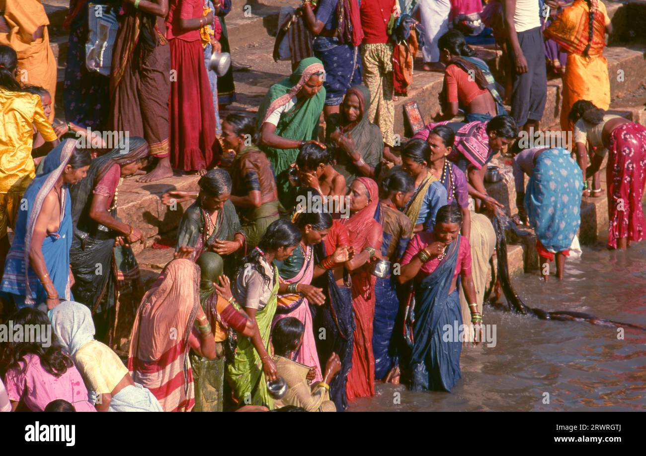 Inde : les pèlerins se baignent dans le réservoir sacré Jogula Bhavi, Saundatti, Karnataka, pendant la foire Shri Yellamma Devi (1994). Chaque année dans le mois hindou de Magh (janvier - février) plus d'un demi-million de personnes se rassemblent autour du minuscule temple de la déesse Yellamma à Saundatti. Yellamma est la patronne des devadasi ou des femmes dédiées au service d'une divinité ou d'un temple. Banque D'Images
