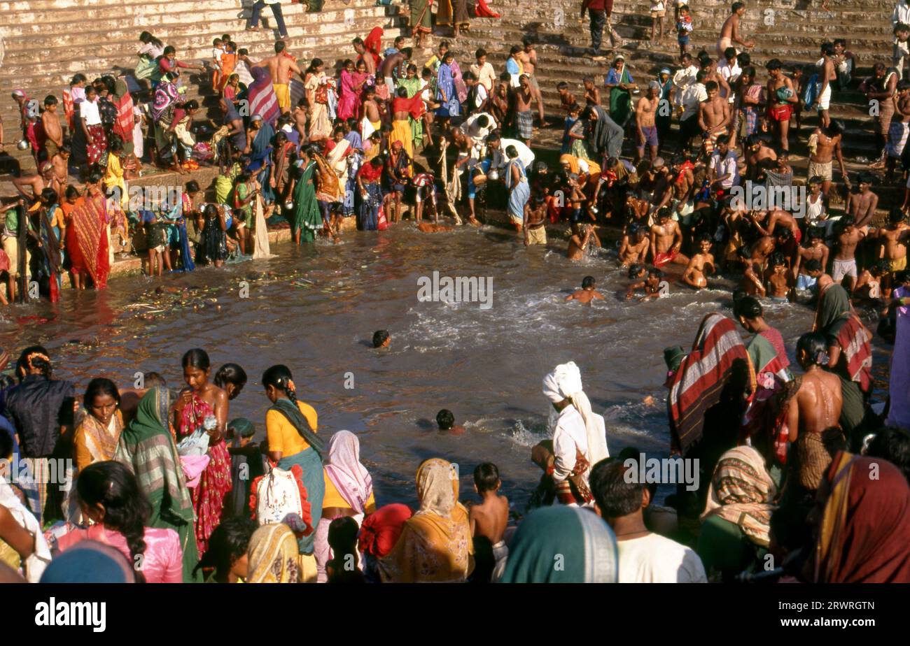 Inde : les pèlerins se baignent dans le réservoir sacré Jogula Bhavi, Saundatti, Karnataka, pendant la foire Shri Yellamma Devi (1994). Chaque année dans le mois hindou de Magh (janvier - février) plus d'un demi-million de personnes se rassemblent autour du minuscule temple de la déesse Yellamma à Saundatti. Yellamma est la patronne des devadasi ou des femmes dédiées au service d'une divinité ou d'un temple. Banque D'Images