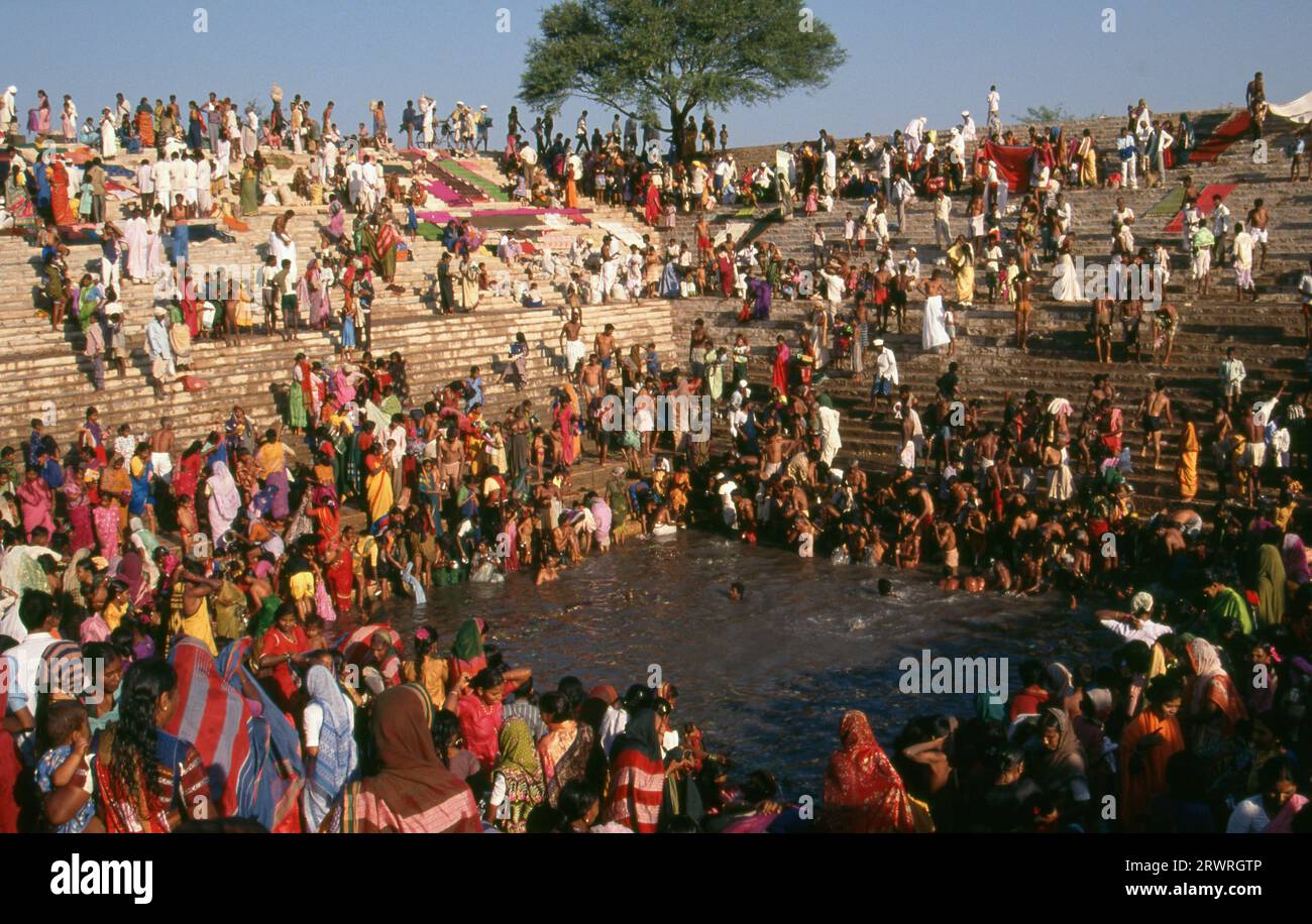 Inde : les pèlerins se baignent dans le réservoir sacré Jogula Bhavi, Saundatti, Karnataka, pendant la foire Shri Yellamma Devi (1994). Chaque année dans le mois hindou de Magh (janvier - février) plus d'un demi-million de personnes se rassemblent autour du minuscule temple de la déesse Yellamma à Saundatti. Yellamma est la patronne des devadasi ou des femmes dédiées au service d'une divinité ou d'un temple. Banque D'Images