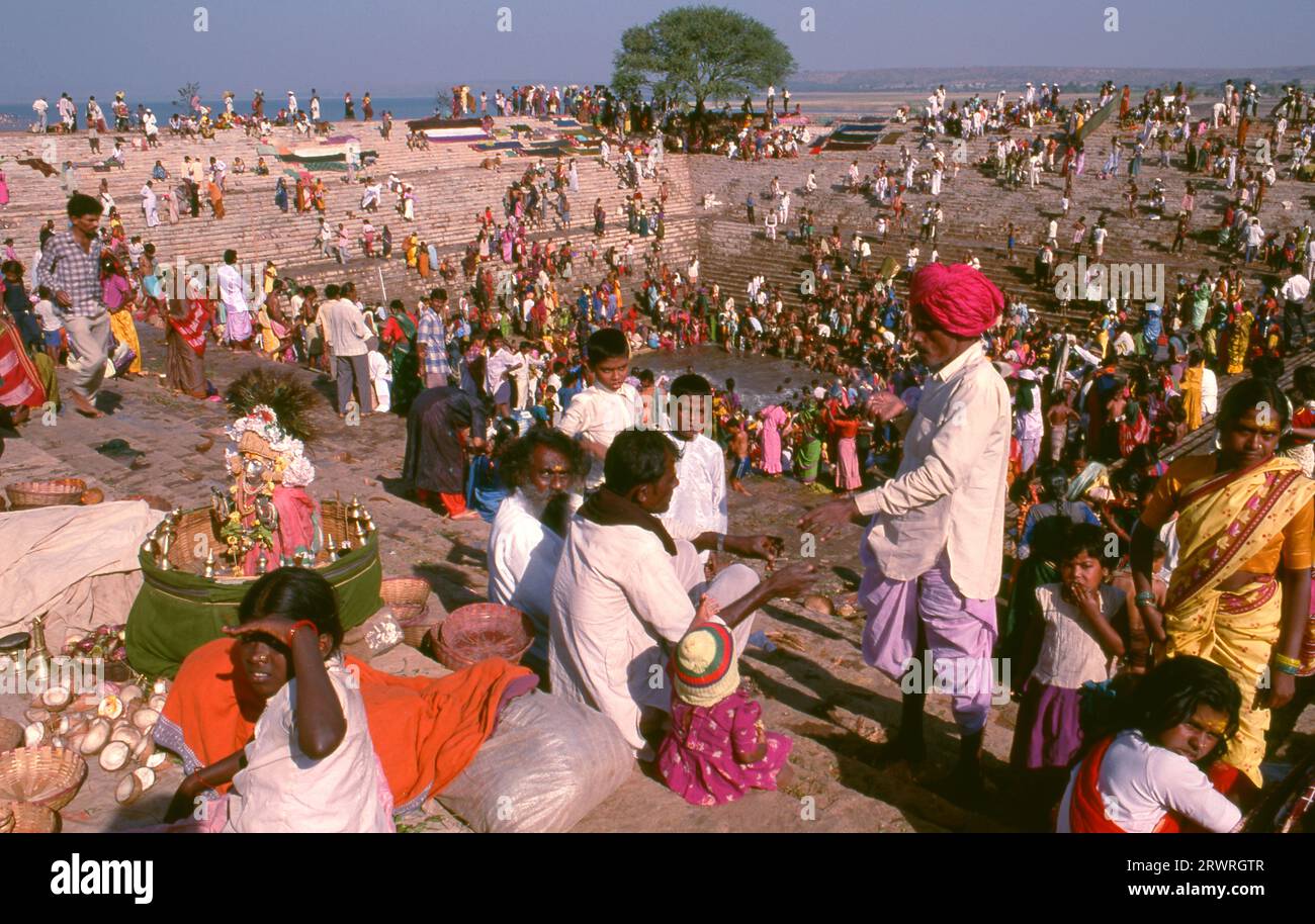 Inde : les pèlerins se baignent dans le réservoir sacré Jogula Bhavi, Saundatti, Karnataka, pendant la foire Shri Yellamma Devi (1994). Chaque année dans le mois hindou de Magh (janvier - février) plus d'un demi-million de personnes se rassemblent autour du minuscule temple de la déesse Yellamma à Saundatti. Yellamma est la patronne des devadasi ou des femmes dédiées au service d'une divinité ou d'un temple. Banque D'Images