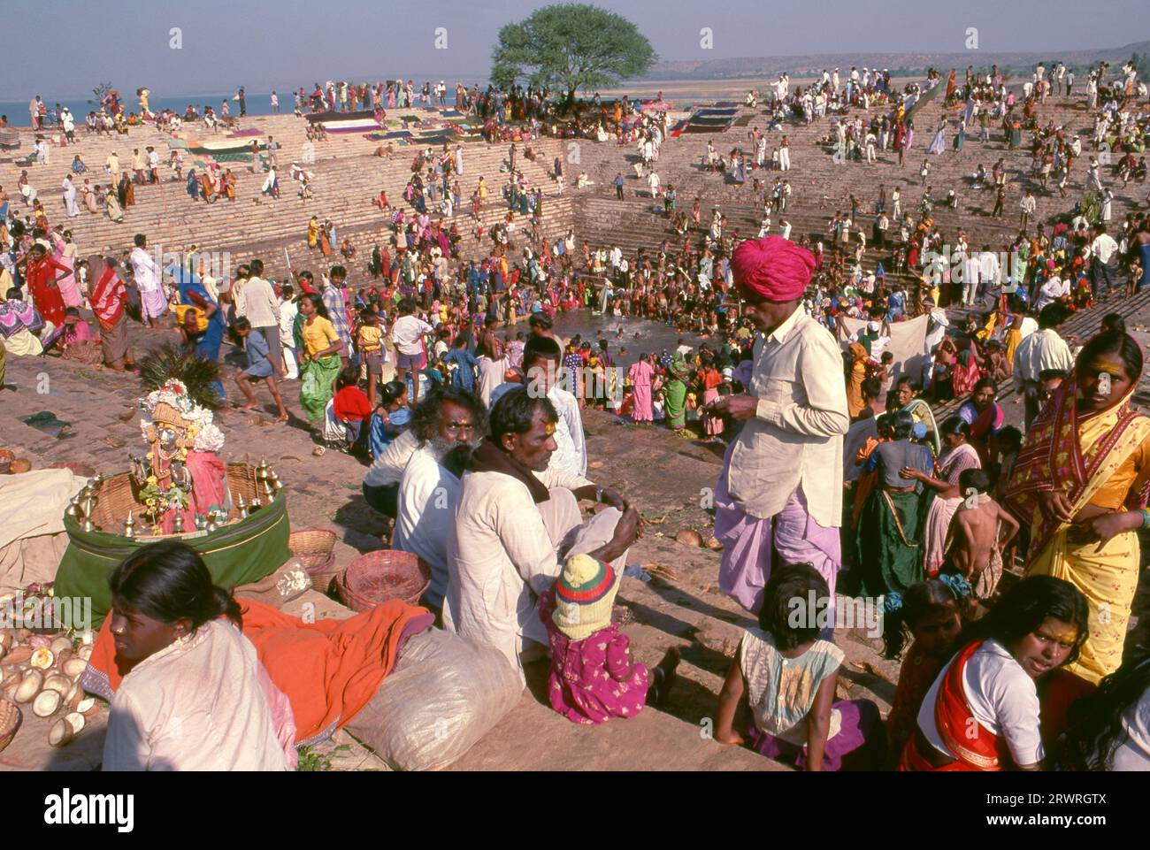 Inde : les pèlerins se baignent dans le réservoir sacré Jogula Bhavi, Saundatti, Karnataka, pendant la foire Shri Yellamma Devi (1994). Chaque année dans le mois hindou de Magh (janvier - février) plus d'un demi-million de personnes se rassemblent autour du minuscule temple de la déesse Yellamma à Saundatti. Yellamma est la patronne des devadasi ou des femmes dédiées au service d'une divinité ou d'un temple. Banque D'Images