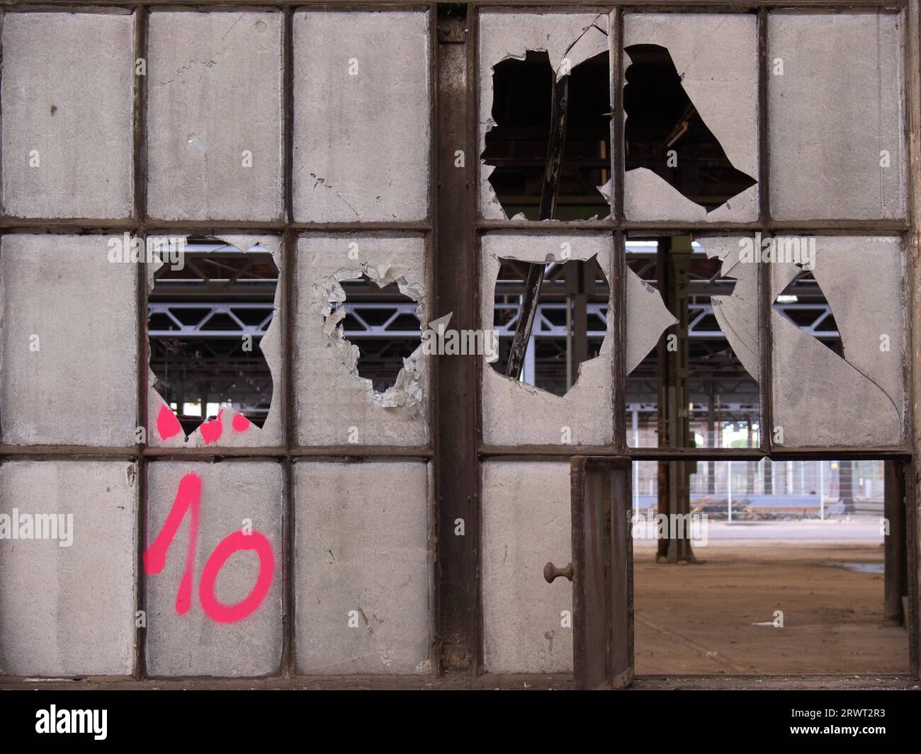 Vitres cassées sur une fenêtre d'une usine délabrée, avec vue sur le bâtiment Banque D'Images